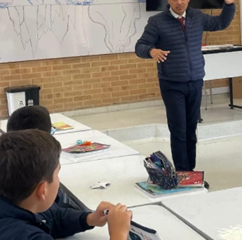 Un profesor dando clase de pie frente a sus estudiantes